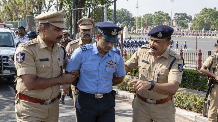 Police personnel detaining a man posing as a fake Indian Air Force officer