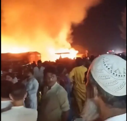 Protesters gather on a highway amid burning fires during protests in Pakistan